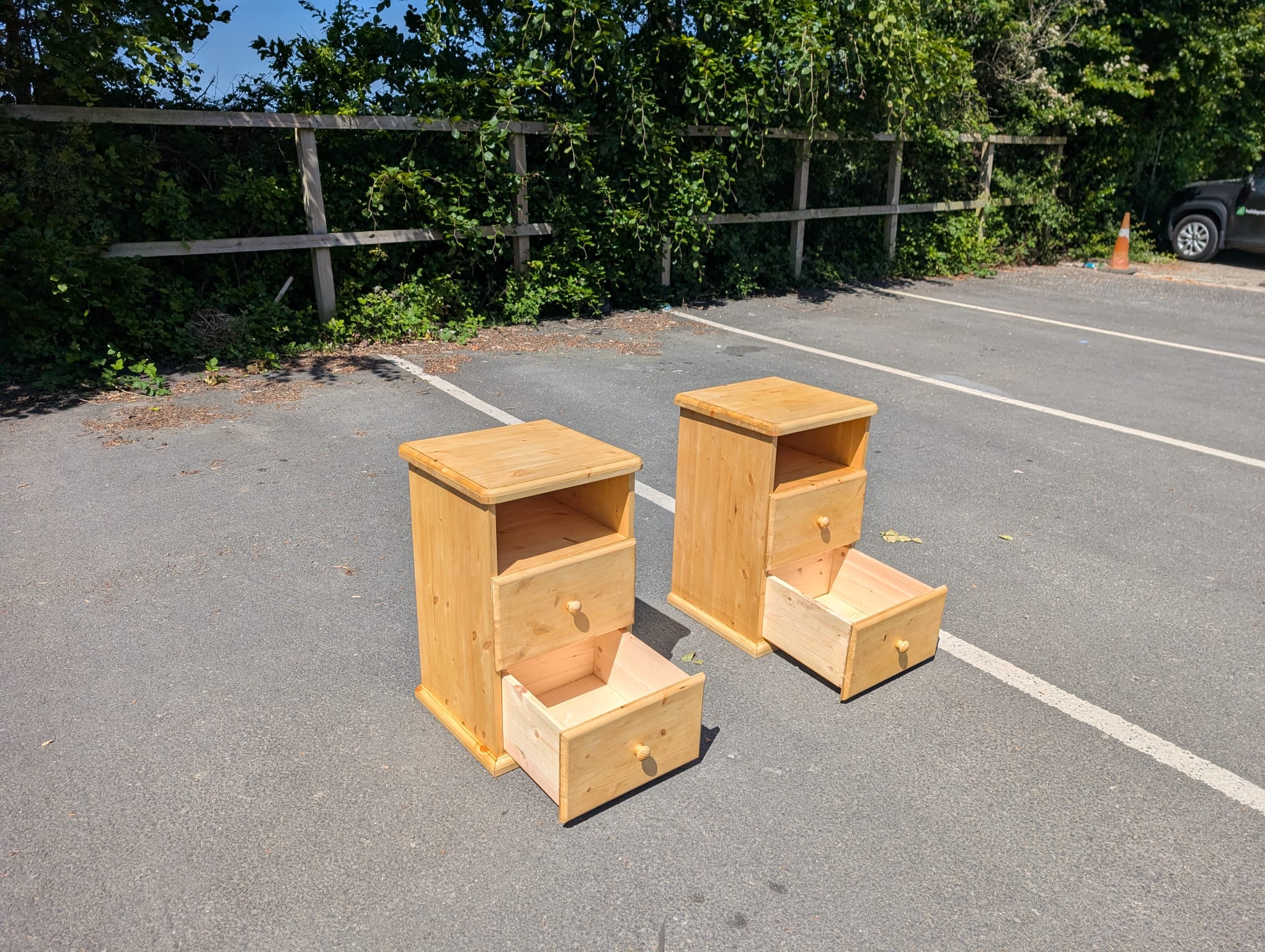 The pair of Bideford Bay bedside cabinets with the bottom drawer pulled out on each, showing the depth of the drawer box.