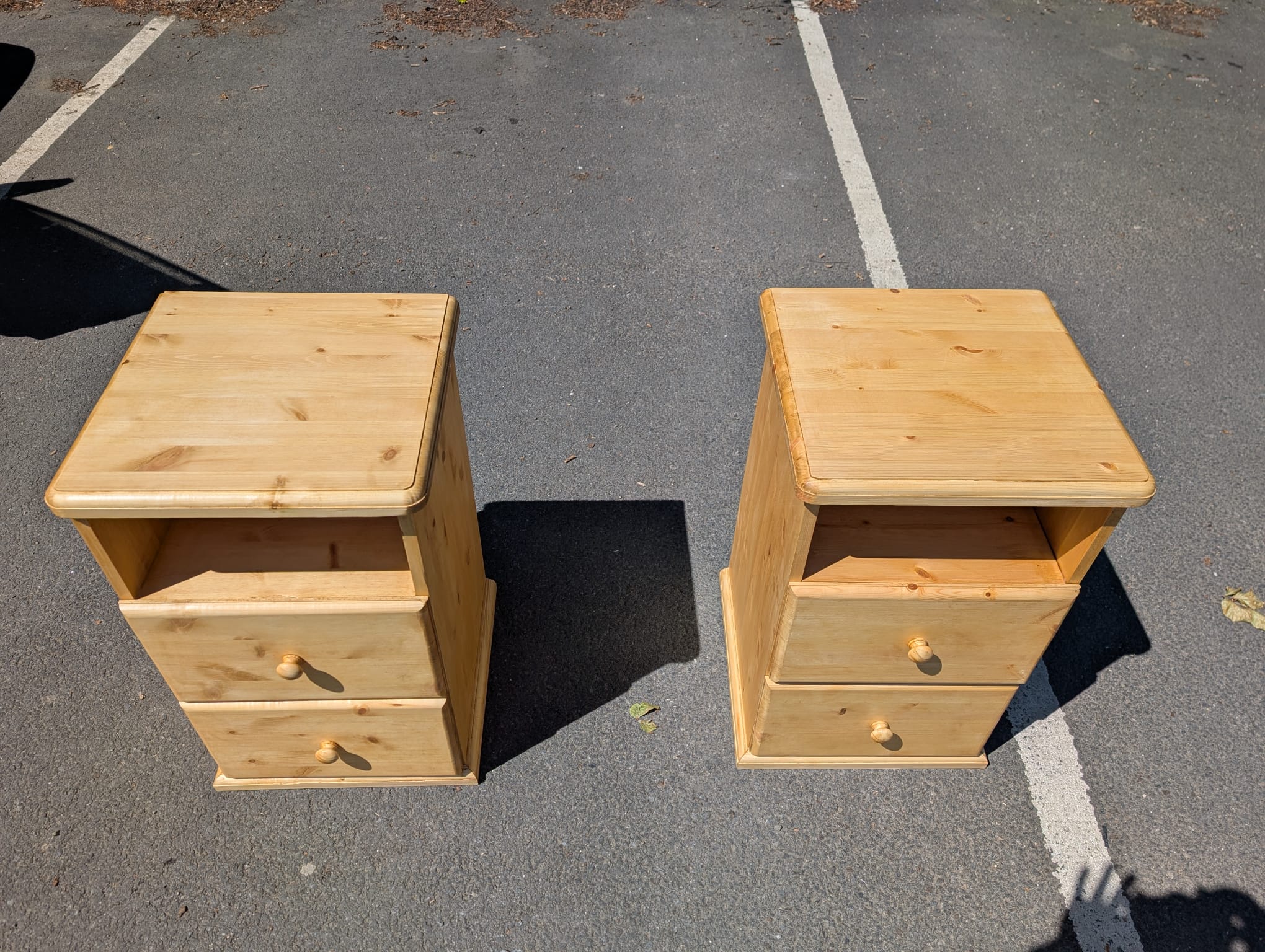 Top-down view of both bedside cabinets showing the chunky pine tops and the open shelf below, where a phone or a lamp would sit.