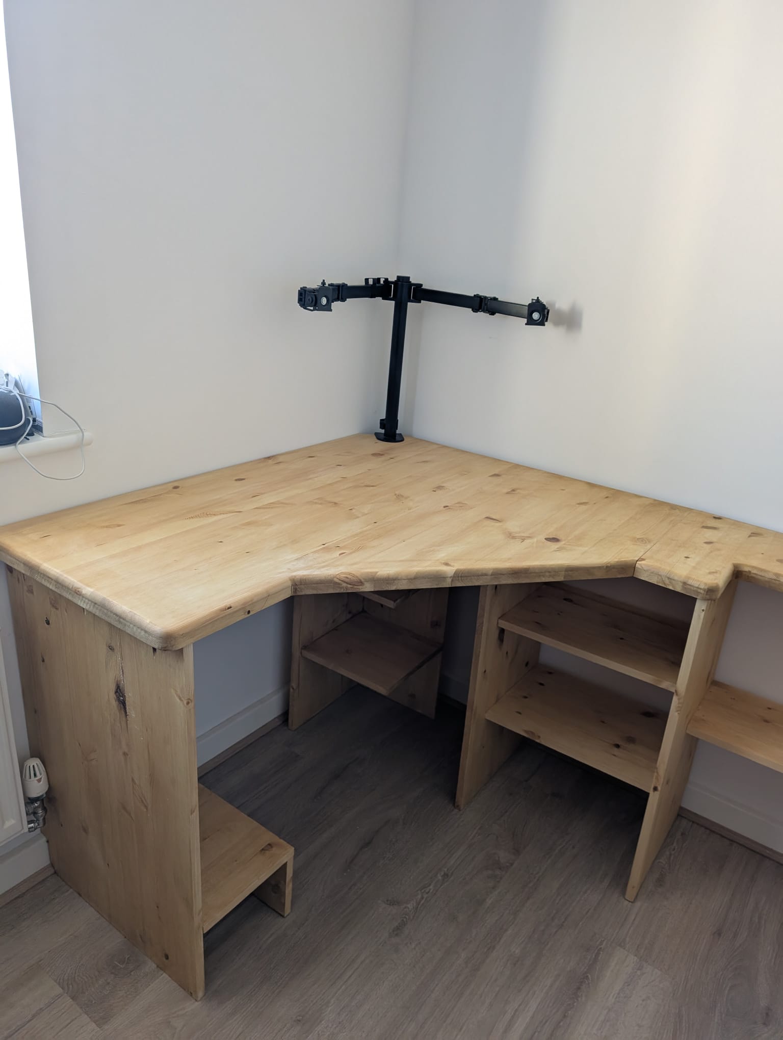 Looking down at the corner of the Croyde Desk, showing the angled twin-bay shelving cubby tucked under the worktop where the two arms meet.